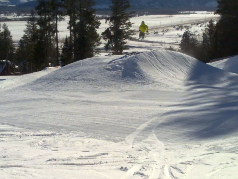 A skier hits one of the kickers in Bronco terrain park.  Bronco terrain park is accessibly by Teewinot lift, and has kickers, rails, spines, boxes, and other obstacles